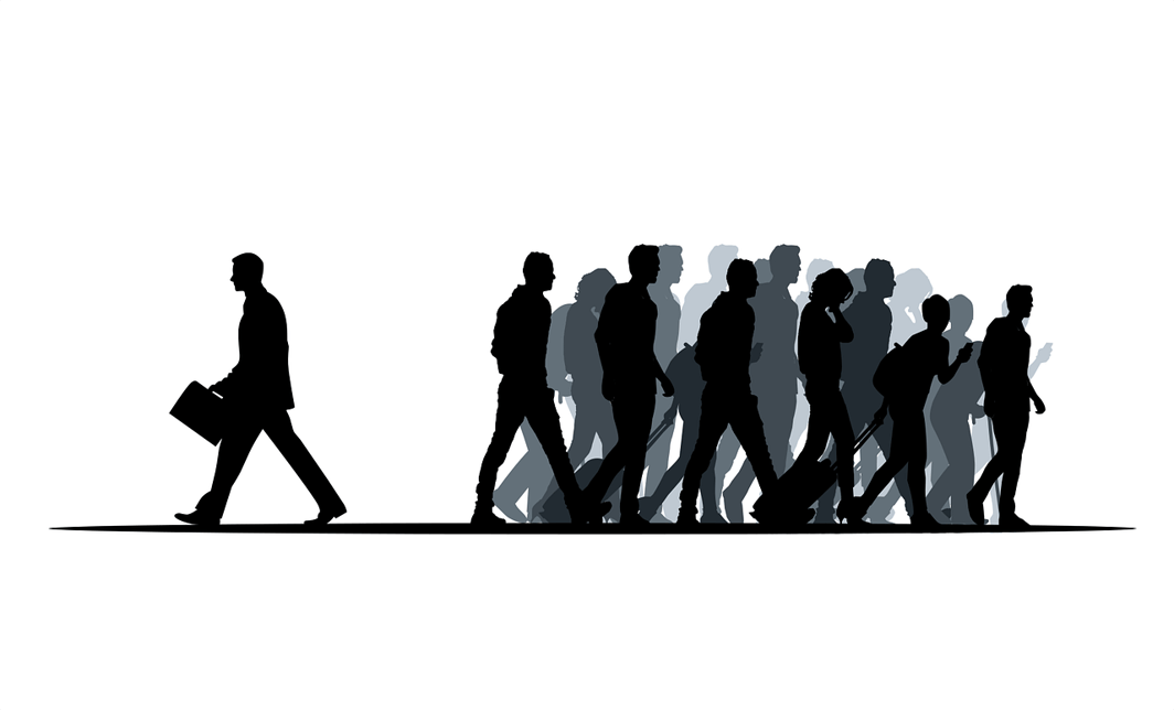 man walking opposite direction of crowd